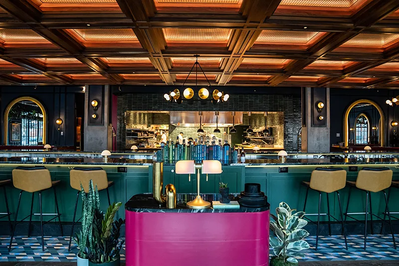 Memoir's dining room and bar with a bright pink bar front