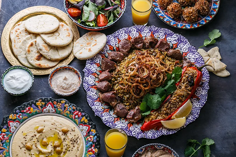 Spread of Greek dishes including pita, dips and grilled meats