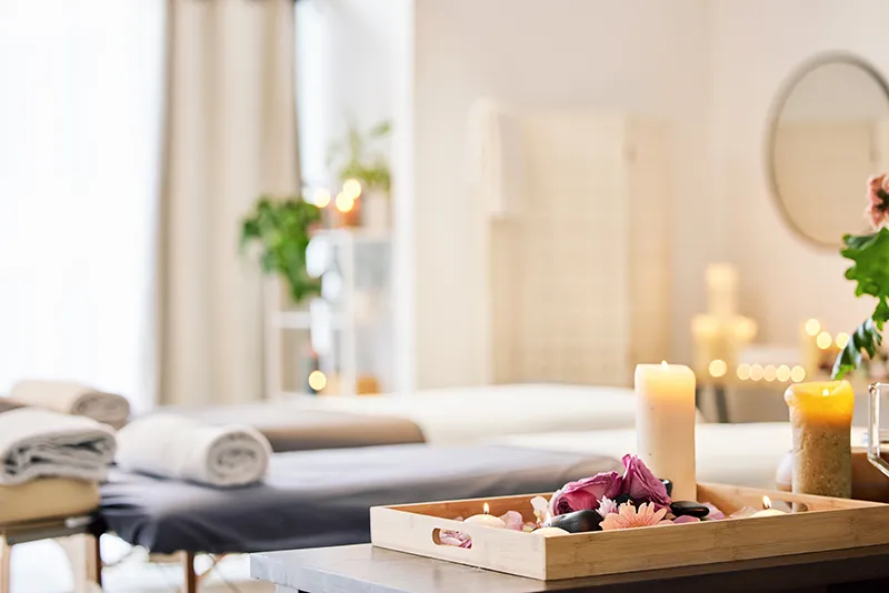 Spa treatment room with candles and folded towels