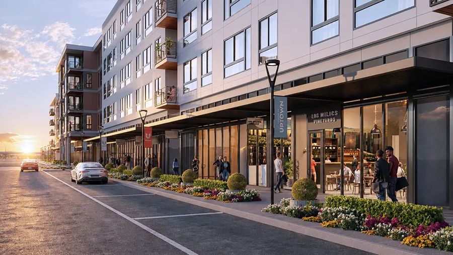 Rendering of a residential street with ground-floor retail at sunset