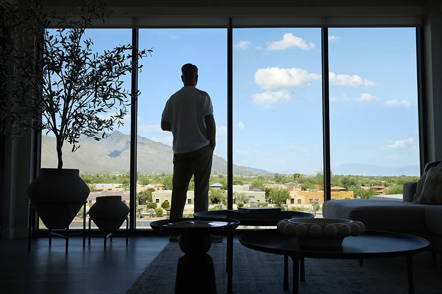 Resident looking out floor-to-ceiling windows at mountain views